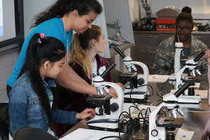 Girls in a lab with microscopes.